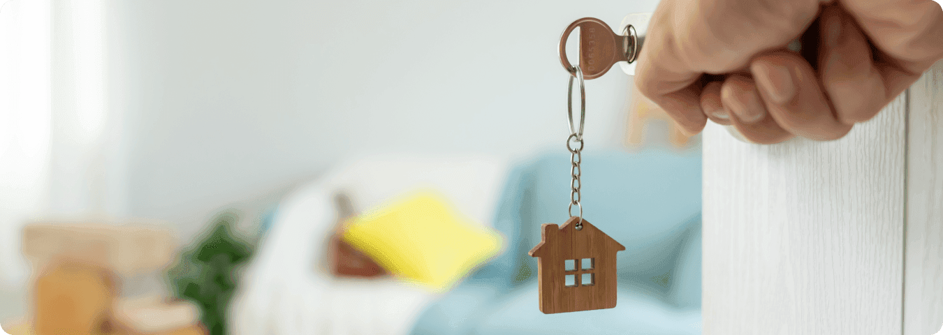 Chave com chaveiro de casa sendo inserida na fechadura, representando a compra de um apartamento novo.